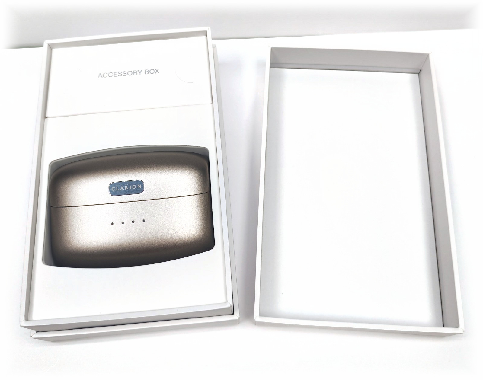 The Clarion presentation box open on white, the champagne charging case seated inside on its tray.